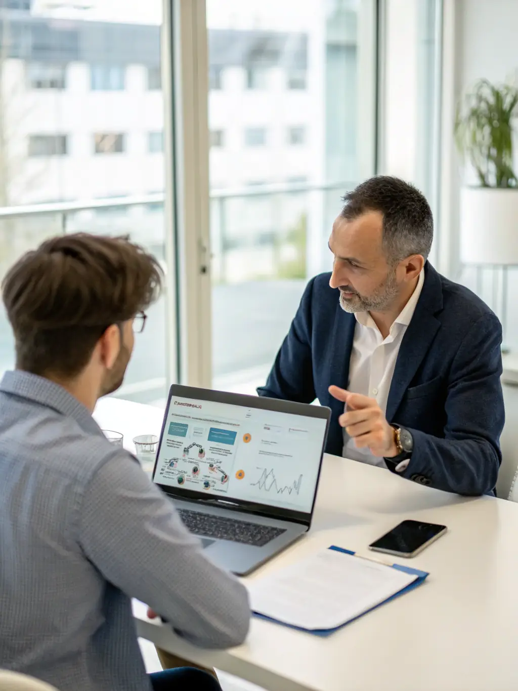A consultant discussing technology strategies with a client, using digital devices to illustrate BexleyWeb's technology consultancy services.